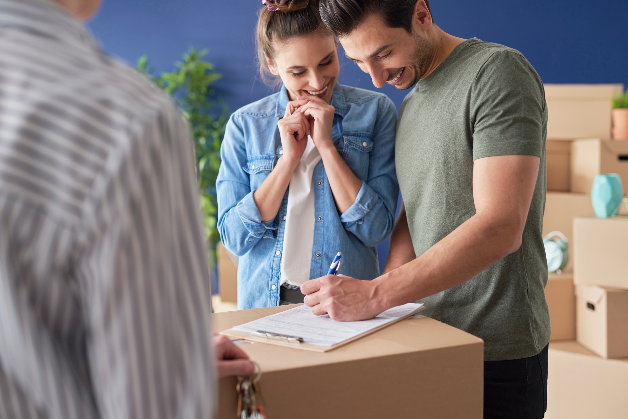 Extremely happy couple signing a house purchase agreement